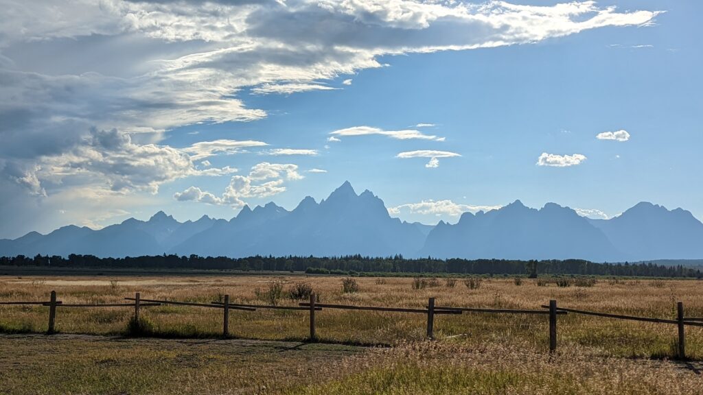 Grand Teton Mountains behind a wooden fence