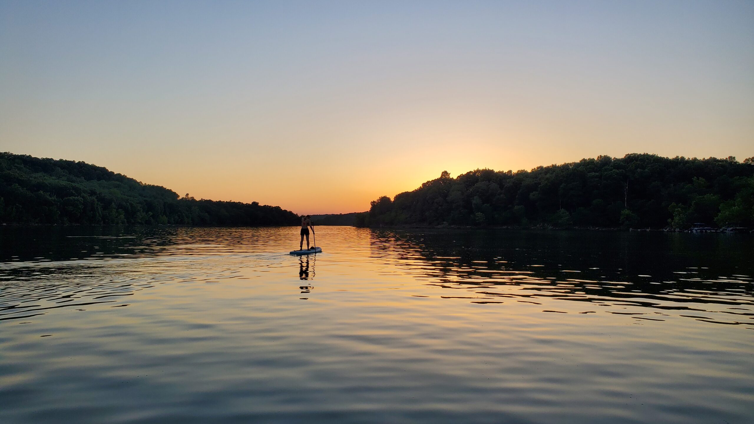 Sunset on the lake with a silhouette of a paddle boarder