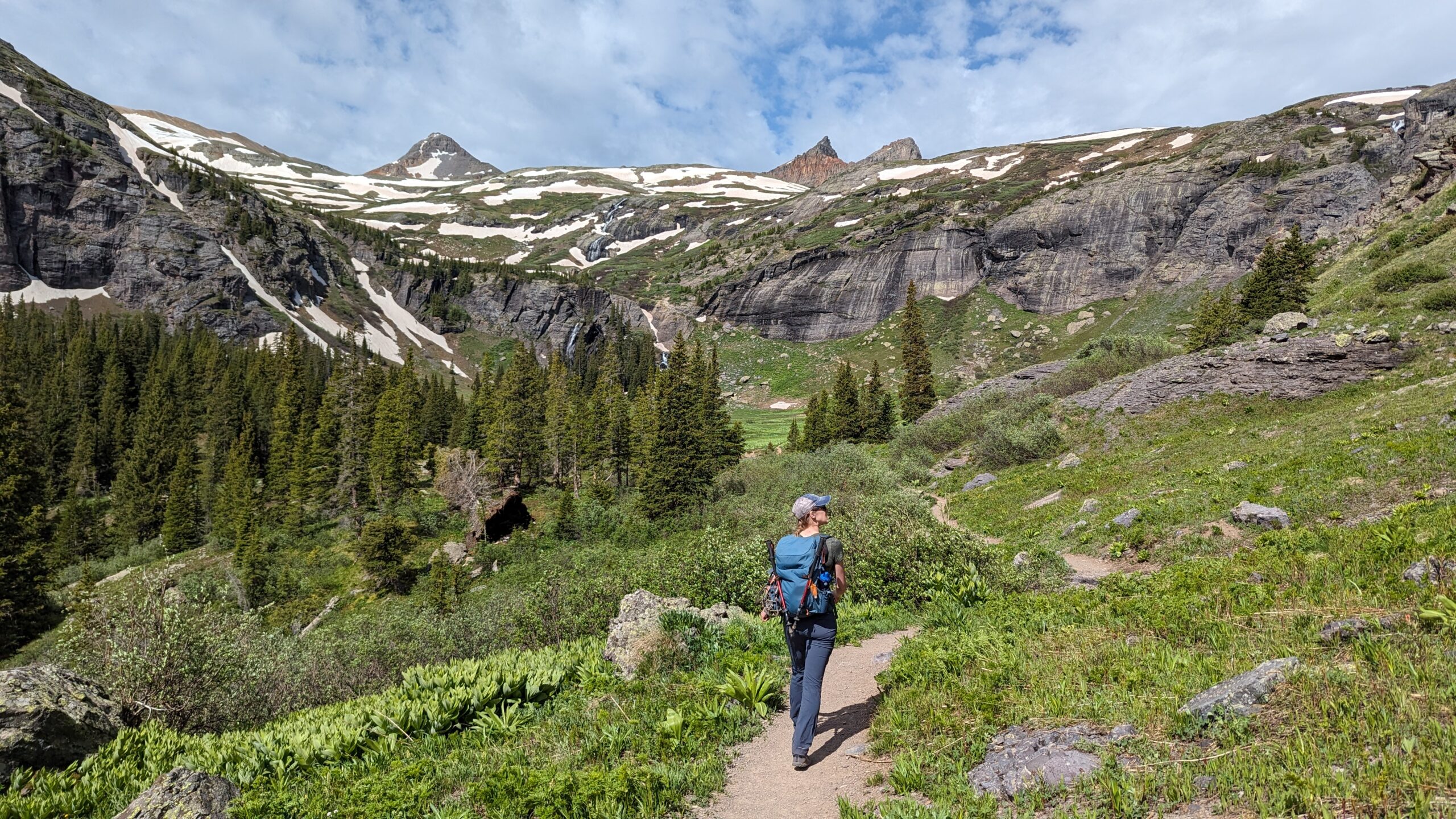 A woman hiking on a trail through the mountains